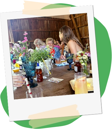 photo of an event in the Martin Blueberries event barn, styled like a polaroid with masking tape, sitting on top of an organic green shape